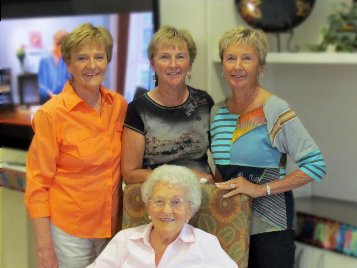 group of four women looking at the camera and smiling