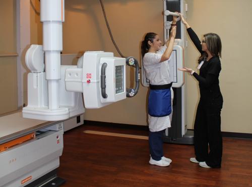 Hfammond-Henry Imaging tech helping a patient in a digital x-ray machine