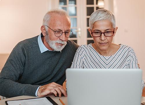 elderly couple looking up care options at Hammond Henry Hospital on their computer